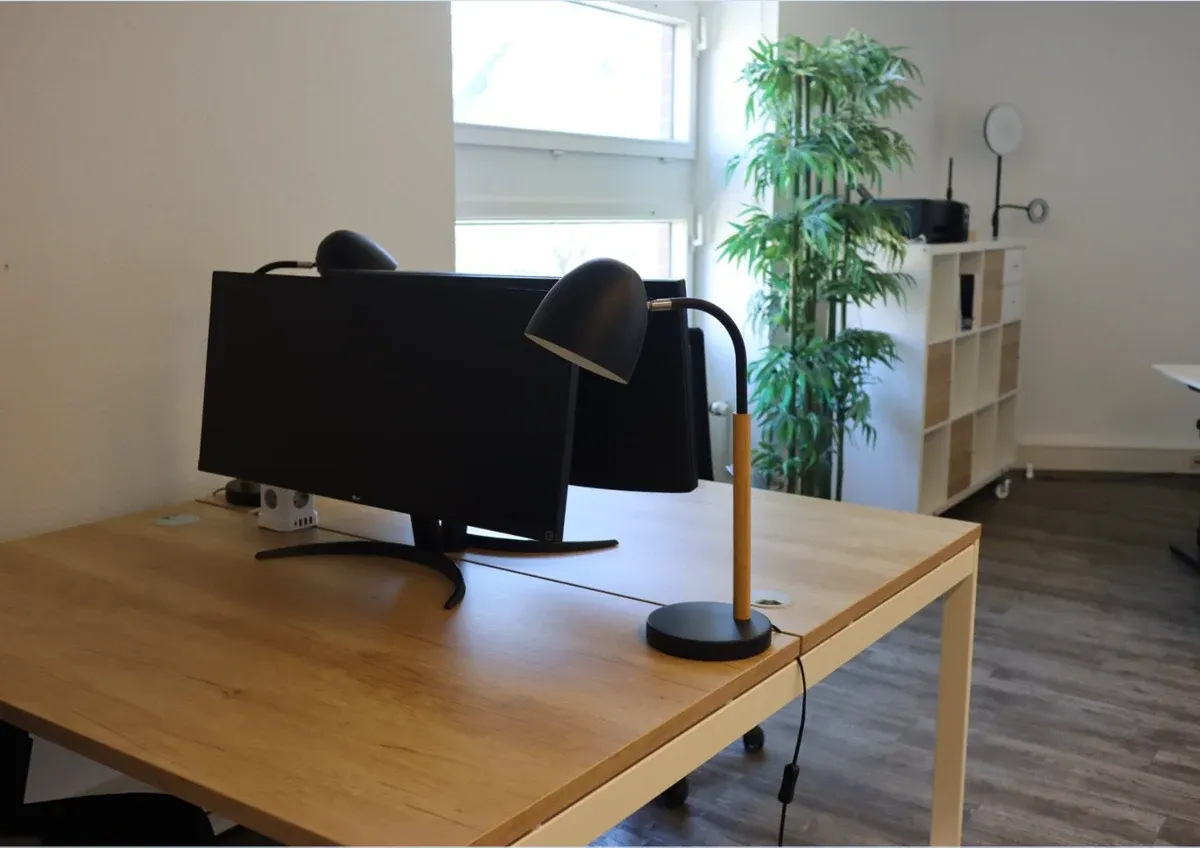 Arbeitsplatz mit Ultrawide-Bildschirm und Schreibtischlampe im Coworking Space Leipzig | Gallmond Coworking